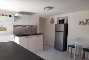 a kitchen with a refrigerator and a table at Maison avec jacuzzi et jardin privé, proche plage in Le Pradet