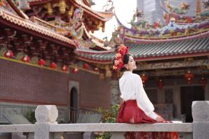 a woman sitting on a fence in front of a building at Shangri-La Xiamen in Xiamen