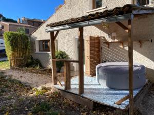 a hot tub under a pergola next to a house at Maison avec jacuzzi et jardin privé, proche plage in Le Pradet