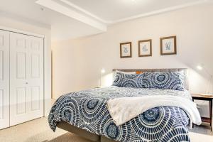 a bedroom with a bed with a blue and white comforter at Jewel by the Sea in Westport +26 photos