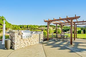 a patio with a grill and a table and chairs at Jewel by the Sea in Westport