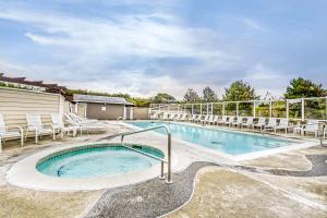 a large swimming pool with chairs and a swimming poolvisor at Jewel by the Sea in Westport