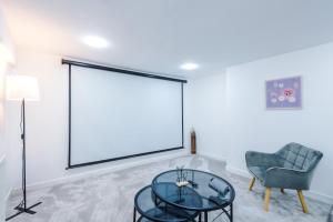 a living room with a glass table and a chair at 6BR Home - Sleeps 15 - Ideal for Contractors & Group Stays - Parking in Castleton