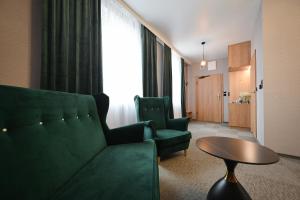 a living room with a green couch and a table at R Zajazd Witnica in Witnica +35 photos