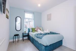 a bedroom with a blue bed with a mirror at 6BR Home - Sleeps 15 - Ideal for Contractors & Group Stays - Parking in Castleton