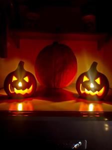 three halloween pumpkins are lit up in the dark at Casa dello Sciatore Lorica in Lorica