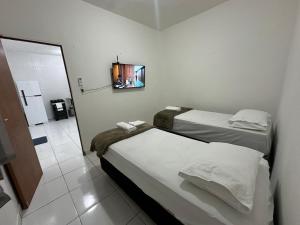 2 Betten in einem kleinen Zimmer mit Spiegel in der Unterkunft Apartamento Flat 303 COP30 in Belém