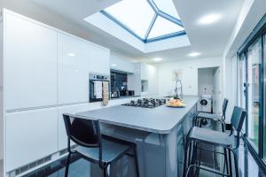 a kitchen with a large island with bar stools at 6BR Home - Sleeps 15 - Ideal for Contractors & Group Stays - Parking in Castleton