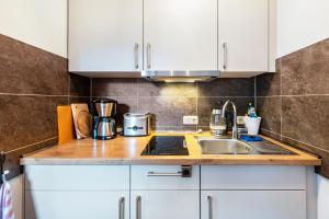 a kitchen with white cabinets and a sink at Fewo Inselblick - am Schweriner See in Flessenow