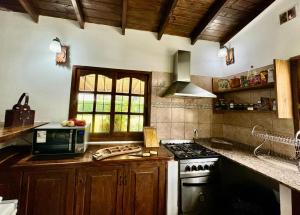 a kitchen with a stove and a microwave at Quinta La Berna in Etchegoyen
