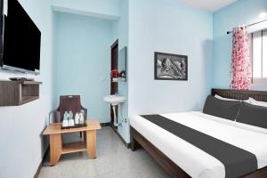 班加罗尔Hotel O Harsha Inn的一间配有床和电视的酒店房间