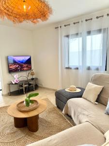 a living room with a couch and a table at Villa Solaya - Sud Sauvage in Saint-Joseph