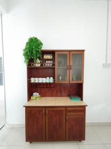 a kitchen with a wooden cabinet with a plant at Ana Homestay Moslim only 4 airconds Wi-Fi in Alor Setar +14 photos