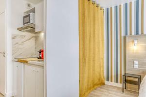 a small kitchen with a sink and a microwave at Colivi Studio Cosy 50m Gare Annemasse in Annemasse