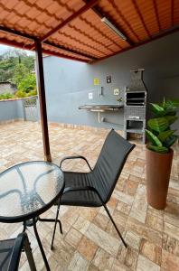 a patio with a glass table and a chair at Quase um Spa in Petrópolis