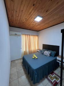 1 dormitorio con cama azul y techo de madera en Las Heras Apart, en Eldorado