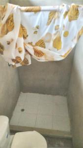 a bathroom with a toilet and a shower curtain at Wira Pora Hostal in Playa Ladrilleros
