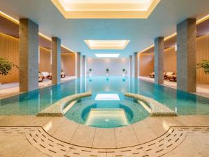a large swimming pool in a hotel lobby at Maison Sofia - MGallery in Sofia