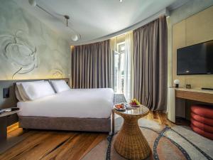 a hotel room with a bed and a television at Maison Sofia - MGallery in Sofia