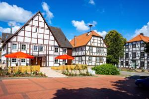 a large building with orange umbrellas in front of it at Landhaus am Schlosspark FeWo 4 in Brakel