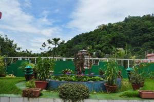 a garden with a statue and plants in front of a fence at Saikia Nest the Home-stay in Guwahati