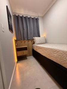 a small room with two beds and a curtain at Apto centro, reformado, churrasqueira Privativa! in Balneário Camboriú