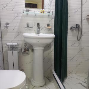 a bathroom with a white sink and a toilet at Hotel Javlonbek 1 in Samarkand