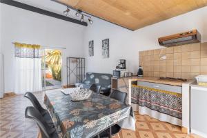a kitchen and dining room with a table and chairs at Gîte Le 878 in Roquefort-des-Corbières
