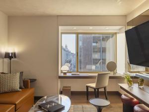 a living room with a couch and a window at Fairmont Golden Prague in Prague