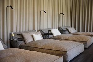 a room with three beds and a couch and lamps at Hotel Die Krone - Immenstadt-Stein in Immenstadt im Allgäu