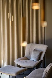 a chair with a pillow in front of a curtain at Hotel Die Krone - Immenstadt-Stein in Immenstadt im Allgäu