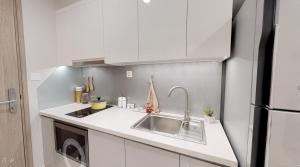 Long BìnhにあるSummer Houseのシンクと冷蔵庫を備えた白いキッチン