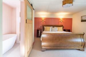 a bedroom with a bed and a bath tub at Waterhen Cottage in Docking