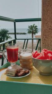 a table with a drink and a bowl of fruit at Alojamiento Oasis Playa in Águilas
