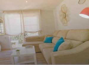 een woonkamer met een bank en een tafel bij Alojamiento Oasis Playa in Águilas +20 foto's