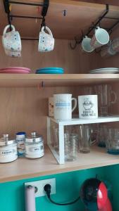 uno scaffale con tazze e altri oggetti sopra di Alojamiento Oasis Playa ad Águilas Altre 19 foto