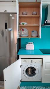 una cucina con lavatrice e frigorifero di Alojamiento Oasis Playa ad Águilas