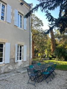 a table and chairs in front of a building at La Tour du Maine in Marmande
