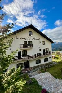 a building with a sign on the side of it at Pensiunea Casa Ancutei in Ranca