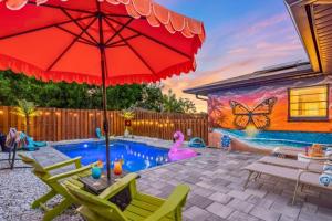 a swimming pool with a red umbrella and a pink swan at Saltwater Siesta Game Room Pool Mini Golf in Sarasota
