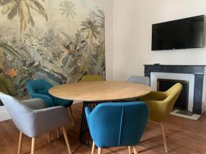 a dining room with a table and chairs and a fireplace at La Tour du Maine in Marmande