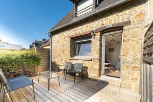 a patio with chairs and tables on a wooden deck at O Ricoul - Maison avec jacuzzi proche Rennes in Corps-Nuds