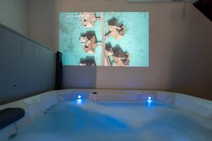 a bath tub with blue lights in a room at O Ricoul - Maison avec jacuzzi proche Rennes in Corps-Nuds +4 photos
