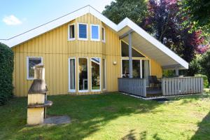 a small yellow house with a yard at Wildgans 65 in Mirow