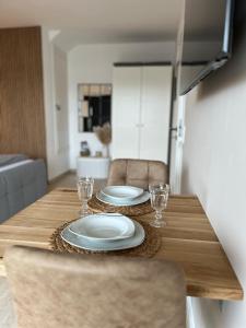 a wooden table with two plates and glasses on it at Cozy apartment in Hagen