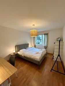 チューリッヒにあるSimple 2BR Apartment with Natural Lightのベッドとテーブルと窓のある寝室