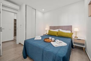 a bedroom with a blue bed with a tray of food on it at Sea View & Shared Pool in Lagos by HostWise in Lagos +14 photos