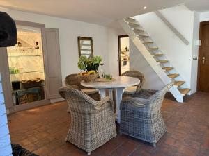 a dining room with a table and wicker chairs at Casa Zuino in Gargnano