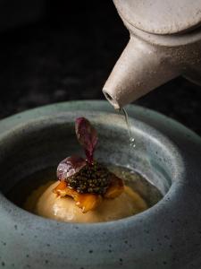 a drink being poured into a bowl of food at Elysium Luxury Stays in Melegis