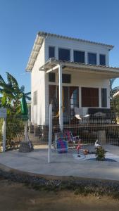 a white house with a playground in front of it at EcoChalé de Arraial in Arraial do Cabo